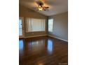 Open living space with hardwood floors, bright windows, and a modern ceiling fan at 3903 S Quemoy Ct, Aurora, CO 80018