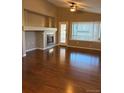Bright living room featuring a fireplace, large windows, and gleaming hardwood floors at 3903 S Quemoy Ct, Aurora, CO 80018