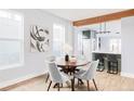 Bright dining area with wood table and gray chairs, open to kitchen at 1838 Race St, Denver, CO 80206