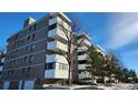 Apartment building featuring balconies and adjacent parking spaces on a partly cloudy day at 10650 E Tennessee Ave # 101, Aurora, CO 80012