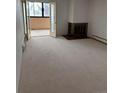 Open living room featuring fireplace, neutral carpet, and sliding glass doors to an enclosed lanai at 10650 E Tennessee Ave # 101, Aurora, CO 80012