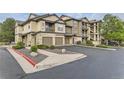 Attractive condo building with stone accents, garages and well-kept landscaping in a parking area at 7418 S Quail Cir, Littleton, CO 80127