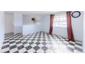Spacious living room showcasing distinctive monochrome checkered floors, and neutral wall color scheme at 7845 Conifer Rd, Denver, CO 80221