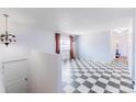 Bright living room with monochrome checkered floors and a large window with lots of natural light at 7845 Conifer Rd, Denver, CO 80221
