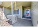 Inviting front porch with stone accents, white railings, and a view of the front door at 9912 Bradbury St, Firestone, CO 80504