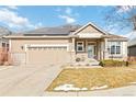 Home exterior showcasing a two-car garage, neutral paint, brick accents, solar panels, and an inviting front porch at 10843 W Hinsdale Dr, Littleton, CO 80127