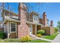 Charming townhome exterior with well-maintained landscaping and brick chimney detail at 14271 E Dickinson Dr # F, Aurora, CO 80014