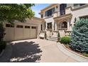 Charming front exterior showcasing a two-car garage and a stately entrance with stone accents at 9171 E Harvard Ave, Denver, CO 80231