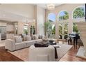 Bright living room featuring hardwood floors, high ceilings, and large arched windows with natural light at 9171 E Harvard Ave, Denver, CO 80231