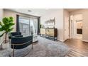 Cozy living room with comfortable seating, modern decor, balcony access, and an open doorway to another room at 6153 N Ceylon St # 303, Denver, CO 80249