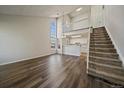 Bright living room features soaring ceilings, large windows, modern floors, and staircase access to the upper level at 8329 W 90Th Pl, Westminster, CO 80021