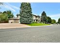 Expansive property featuring a meticulously kept lawn with mature trees and a circular driveway at 5329 S Geneva St, Englewood, CO 80111