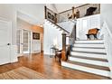 Grand foyer with hardwood floors, staircase with iron railing, and wainscoting detail at 5329 S Geneva St, Englewood, CO 80111