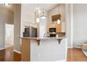 Open kitchen features stainless steel appliances, granite countertops, and breakfast bar at 8638 Gold Peak Dr # D, Highlands Ranch, CO 80130