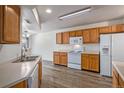 Bright kitchen boasts wood cabinets, white appliances, and modern flooring for a clean and functional space at 19172 E Arkansas Dr # 106, Aurora, CO 80017