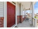 Inviting front porch with classic columns and a red front door with the house number 4401 at 4401 Hydrangea Way, Castle Rock, CO 80109