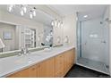 Modern bathroom featuring double sinks, a large mirror, and a glass-enclosed shower at 1878 W 32Nd Ave, Denver, CO 80211