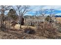 Exterior of home surrounded by bare trees and brush at 18258 W 58Th Pl # 1, Golden, CO 80403