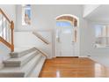 Bright foyer with hardwood floors, staircase, and a view of the front entrance, highlighting the open space at 534 Stonemont Dr, Castle Pines, CO 80108