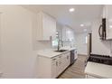 Bright kitchen with white cabinets, stainless steel appliances, and wood-look flooring at 5090 Tejon St, Denver, CO 80221