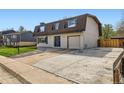 A two-story home featuring an attached garage with a spacious driveway, and well-kept lawn at 5203 Scranton St, Denver, CO 80239