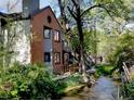 A beautiful view of a brick apartment complex with a stream and bridge at 1633 18Th St St # 2, Boulder, CO 80302