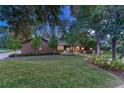 Landscaped front yard with mature trees and lush green lawn at 5795 Oak Creek Ln, Greenwood Village, CO 80121