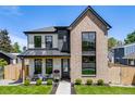 Charming two-story home featuring a modern exterior with a brick facade, well-manicured lawn, and covered porch at 2540 Jay St, Edgewater, CO 80214