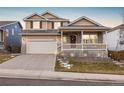 Two-story house with a beige exterior, front porch, and attached two-car garage at 13735 Steele Ct, Thornton, CO 80602