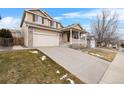 Two-story house with a beige exterior, front porch, and attached garage at 13735 Steele Ct, Thornton, CO 80602