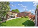Spacious backyard with a covered patio, lush green lawn, and mature landscaping, perfect for outdoor entertaining at 11349 Downing Dr, Northglenn, CO 80233