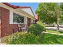 Inviting front porch with seating, surrounded by colorful flowers and well-manicured landscaping at 11349 Downing Dr, Northglenn, CO 80233