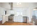 Bright kitchen features stainless steel appliances, white cabinets, and a center island with a sink at 7010 W 44Th Ave, Wheat Ridge, CO 80033