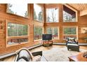 Bright living room with floor to ceiling windows and wood paneled walls at 387 Pine Dr, Idaho Springs, CO 80452