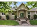 Charming home featuring a green front door, beautiful landscaping, and a welcoming entrance at 1235 S Balsam St, Lakewood, CO 80232