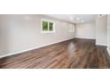 Spacious living room with beautiful wood-look floors and abundant natural light from two windows at 1001 Victor St, Aurora, CO 80011