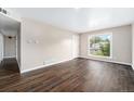Bright living room with wood-look floors, a large window, and neutral walls for a modern feel at 1001 Victor St, Aurora, CO 80011