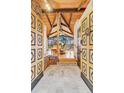 Grand foyer featuring custom wood doors and stone floors leading to a sun-soaked living area with stunning views at 994 Timber Ln, Boulder, CO 80304
