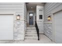 Inviting front entrance with a decorated door, exterior sconces, and well-manicured stone accents at 5072 Silver Hare Ln, Castle Rock, CO 80104
