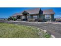 This home has an extensive porch, natural wood accents, and a gravel driveway at 55610 E 40Th Ave, Strasburg, CO 80136