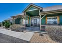Inviting covered front porch with a cozy seating area and natural wood beams at 55610 E 40Th Ave, Strasburg, CO 80136