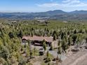 Remote mountain home surrounded by lush forest and beautiful mountain views beyond at 32091 Black Widow Dr, Conifer, CO 80433