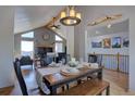 Well-appointed dining area showcasing a wooden table, vaulted ceilings, and a cozy fireplace for memorable gatherings at 32091 Black Widow Dr, Conifer, CO 80433