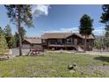 Beautiful multi-story home boasting a lush green yard and three car garage at 32091 Black Widow Dr, Conifer, CO 80433