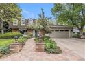 Charming home featuring manicured landscaping, brick accents, and a two-car garage at 10158 E Fair Cir, Englewood, CO 80111
