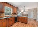 Well-appointed kitchen with wooden cabinetry, granite countertops, and hardwood floors at 10158 E Fair Cir, Englewood, CO 80111