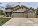 Exterior view showing the three-car garage and driveway at 11895 Hitching Post Ct, Parker, CO 80134