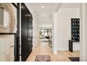 Bright entryway with light wood floors, modern decor, black doors, and views of the home interior at 633 Dexter St, Denver, CO 80220