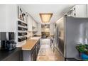 Galley kitchen with updated stainless steel appliances and butcher block countertops at 8746 Carr Loop, Arvada, CO 80005