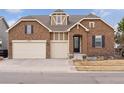 Charming stone home featuring a three-car garage, front door, manicured front yard and welcoming curb appeal at 23635 E Del Norte Pl, Aurora, CO 80016